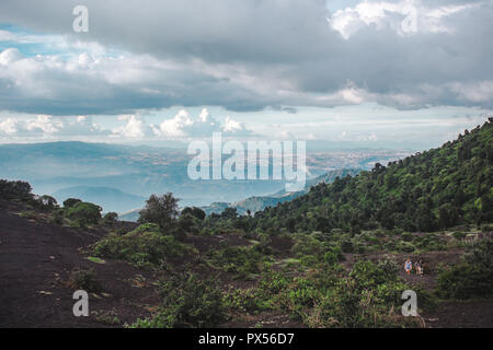 Touristen Wanderung thehanging Landschaften rund um den Vulkan Pacaya, einer der aktivsten Vulkane Guatemalas, aus schwarzem Vulkangestein zu üppig grüne Wälder Stockfoto