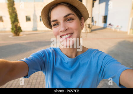 Ergebnis selfie Bild einer schönen jungen Frau lächelnd, während sie einen Hut tragen und einem blauen T-Shirt Stockfoto