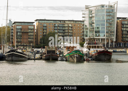 Binnenschiffe und größere Boote sicher an die Verankerungen von der ruhigen und friedlichen Limehouse Basin, London, UK in der Nähe der Themse im Oktober befestigt Stockfoto