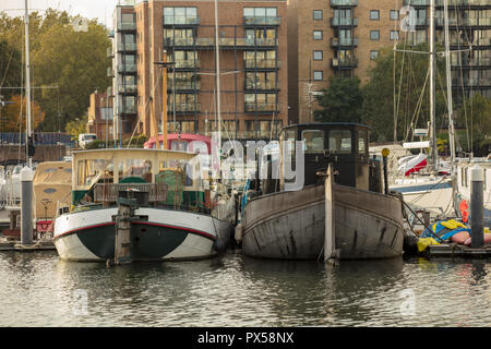 Binnenschiffe und größere Boote sicher an die Verankerungen von der ruhigen und friedlichen Limehouse Basin, London, UK in der Nähe der Themse im Oktober befestigt Stockfoto