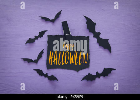 Halloween Urlaub minimal Draufsicht Bild der Brief mit Text Happy Halloween über Holz- violetten Hintergrund. Karte und Einladung Konzept Stockfoto