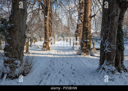 Schneebedeckten Weg durch den Kirchhof der St. Mary's Church in Boston Spa, West Yorkshire Stockfoto