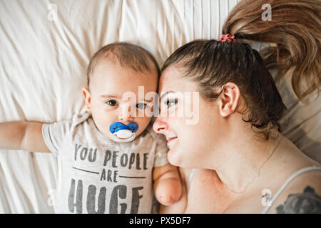 Porträt der schönen Mom das Spielen mit Ihrem 8 Monate alten Baby im Schlafzimmer, Ansicht von oben Stockfoto