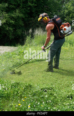 Gardner schneiden das Gras kurz mit brushcutter. Frankreich. Stockfoto