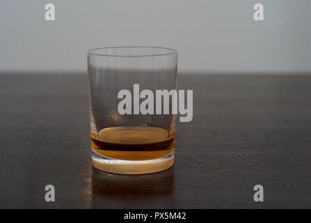 Whiskey, Bourbon, Scotch oder Rum in einem eleganten Tumbler auf einem dunklen Holztisch Stockfoto