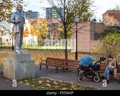 Moskau, Russland - Oktober 16, 2018: Frau mit Kinderwagen sitzen auf der Bank in der Nähe von Alte Statue von Lenin im Golovanovsky Lane von Aeroport Wohngebiet distric Stockfoto
