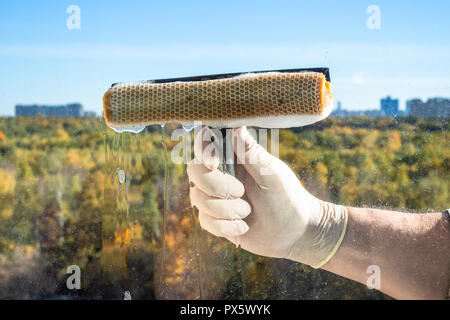 Männliche hand Tücher ein Haus Fenster Glas in der Stadt im sonnigen Herbsttag Stockfoto