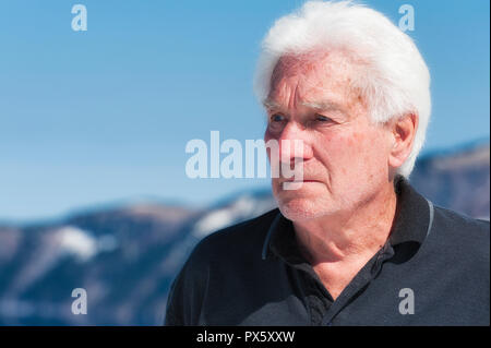 Ein gut aussehender älterer Mann mit Kratersee im Hintergrund Stockfoto