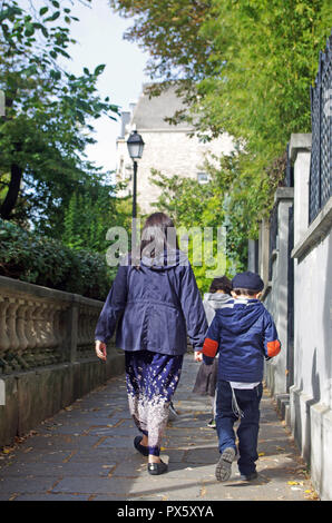 Ein Kind und seine Mutter, die in den ruhigen Straßen von Paris Montmartre Stockfoto