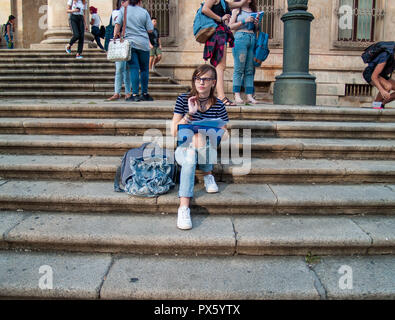 Ein Teenager Frau Studium mit einem Binder auf der Treppe einer Universität in einem Campus der Universität Stockfoto