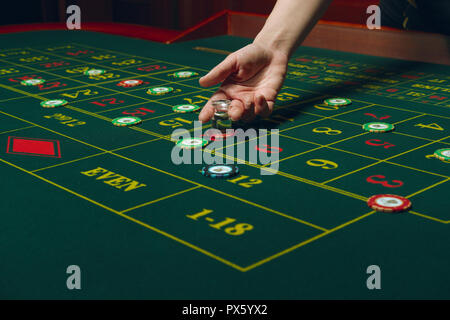 Casino pocker Tabelle mit Chips und Karten. Gewinnende Kombination. Hand des Croupier hinter dem Spieltisch. Stockfoto