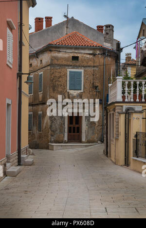 Ruhe Frühjahr Straße mit historischen und neuen Häusern. Bewölkter Himmel. Omisalj, Insel Krk, Kroatien. Stockfoto