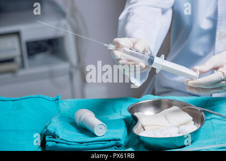 Nahaufnahme der Hand einer Frau Doktor, bereitet eine amniozentese Nadel für das Fruchtwasser Extraktion Stockfoto