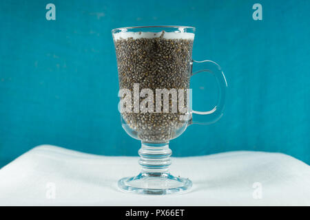 Korn Chia gemischt mit Saft und Milch im Glas Becher auf eine leichte Stoff Tuch. Stockfoto