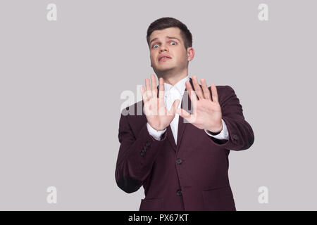 Verstehen Sie mich bitte nicht berühren. Portrait von Angst hübscher junger Mann in Anzug und weißes Hemd, stehend, mit Blick auf die Kamera mit Furcht und Blockierung mit Händen. ich Stockfoto
