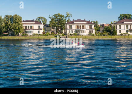 St. Petersburg, Russland, August 2018: Wohngebiet Hütten auf Deputatskaya Straße am Ufer des Flusses Srednyaya Nevka, Personen mit Jet Skis Stockfoto