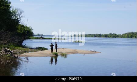 Paar stehen auf dem Strand am Fluss im sonnigen Sommertag. Stockfoto