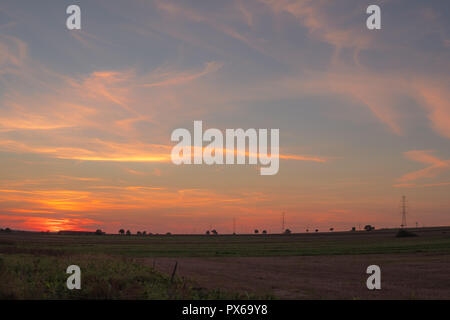 Malerische Landschaft der Felder bei Sonnenuntergang mit bunten Himmel und cirro Stratus Wolken Stockfoto