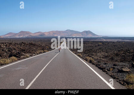 Lanzarote, Spanien - Juni 9, 2017: Perfekt gerade Straße zwischen dem vulkanischen bleibt Stockfoto