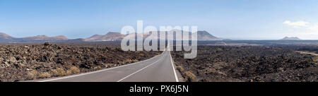 Lanzarote, Spanien - Juni 9, 2017: Perfekt gerade Straße zwischen dem vulkanischen bleibt Stockfoto