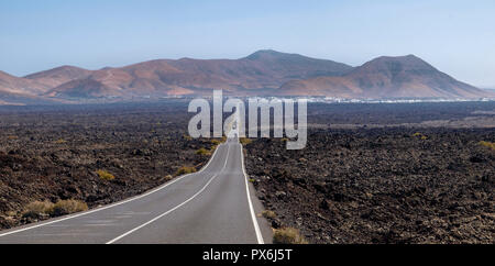 Lanzarote, Spanien - Juni 9, 2017: Perfekt gerade Straße zwischen dem vulkanischen bleibt Stockfoto