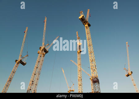 Eine Reihe von Sisk Krane stehen im Leerlauf am frühen Abend auf der Website der Circle Square Komplex auf der Oxford Road, Manchester, UK. Stockfoto