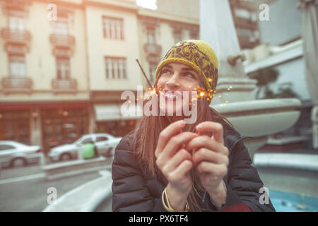 Schöne junge Frau Gefühl glücklich, holding Feuer Wunderkerzen Stockfoto