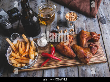 Fried Chicken Wings, Pommes frites, Nüsse, weiße und rote Sauce. Bier eingestellt Stockfoto