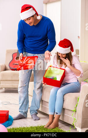 Junges Paar Weihnachten zu Hause feiern. Stockfoto