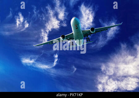 Eine Nahaufnahme skyscape Ansicht eines kommerziellen Passagierflugzeugen flyng in einem pulsierenden blauen Himmel mit hellen, weißen wispy cirrus Wolken. Australien. Stockfoto