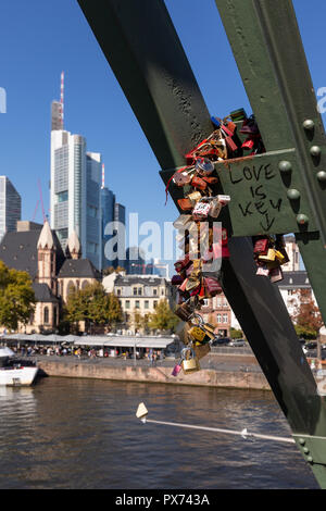 Frankfurt, Deutschland, am 14. Oktober. 2018 - Fußgängerbrücke über den Main mit Liebe Schlösser und Skyline unscharf im Hintergrund. Stockfoto