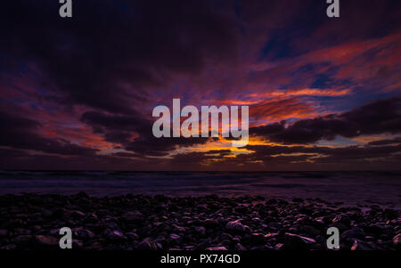 Sonnenaufgang am Praia de Igrejinh mit dramatischen bunte Himmel und Rock, Insel Sal in der Nähe von Santa Maria, Cabo Verde Stockfoto