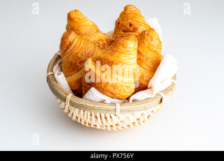 Butter Croissants in kleinen Weidenkorb. Auf weissem Hintergrund. Stockfoto