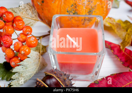 Kastanien in der Shell, Kerze im Glas und herbstliche gefallen Ahornblätter auf der hölzernen Hintergrund, fallen noch Leben Stockfoto