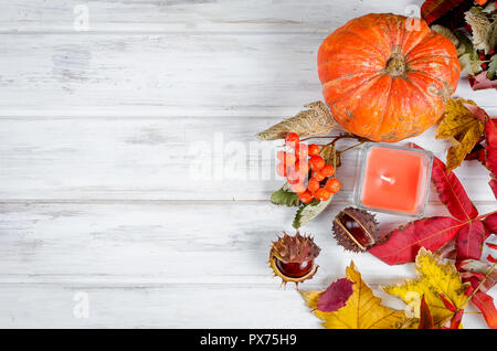 Kastanien in der Shell, Kerze im Glas und herbstliche gefallen Ahornblätter auf der hölzernen Hintergrund, fallen noch Leben Stockfoto