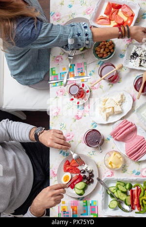 Türkisches Frühstück mit simit (Bagel) Pfannkuchen, Käse, Cherry Tomaten, Gurken, und Tee auf eine Tabelle, Ansicht von oben Stockfoto