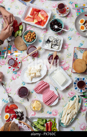 Türkisches Frühstück mit simit (Bagel) Pfannkuchen, Käse, Cherry Tomaten, Gurken, und Tee auf eine Tabelle, Ansicht von oben Stockfoto