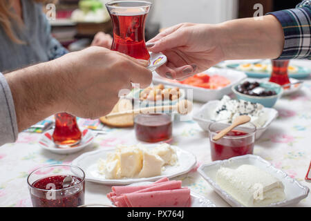 Türkisches Frühstück mit simit (Bagel) Pfannkuchen, Käse, Cherry Tomaten, Gurken, und Tee auf einem Tisch, Nahaufnahme, selektiver Fokus Stockfoto