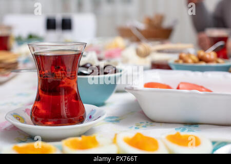 Türkisches Frühstück mit simit (Bagel) Pfannkuchen, Käse, Cherry Tomaten, Gurken, und Tee auf einem Tisch, Nahaufnahme, selektiver Fokus Stockfoto