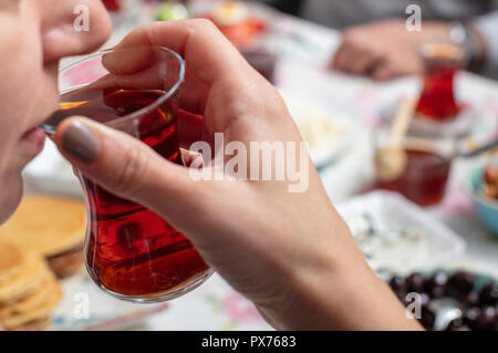 Türkisches Frühstück mit simit (Bagel) Pfannkuchen, Käse, Cherry Tomaten, Gurken, und Tee auf einem Tisch, Nahaufnahme, selektiver Fokus Stockfoto