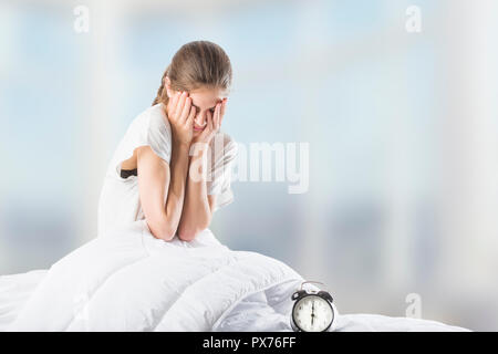 Eine schöne junge Frau im Bett und rieb ihre Augen nach Ihrem Morgen aufwachen Stockfoto