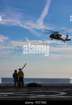 181017-N-HG 389-0058 ATLANTIK (Okt. 2010) 17, 2018) Segler Zug eine vertikale Auffüllung mit einem MH-60S Sea Hawk Hubschrauber zum "Ladegeräte" der Hubschrauber Meer Combat Squadron (HSC) 26 zugeordnet auf dem Flugdeck des amphibious Transport dock Schiff USS Arlington LPD (24) Während der Carrier Strike Group (CSG) 4 composite Trainingsgerät Übung (COMPTUEX). COMPTUEX ist die letzte Übung vor der Bereitstellung, dass der kombinierte Kearsarge Amphibious Ready Group (ARG) und (MEU) Fähigkeiten des 22 Marine Expeditionary Unit militärische Operationen auf See und an Land zu führen t bescheinigt Stockfoto