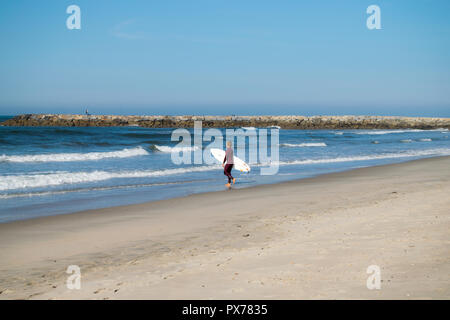 Ofir Beach in Portugal, Surfspot, Surfer hält sein Surfbrett und schaut auf die Wellen, die bereit sind zu surfen. Stockfoto