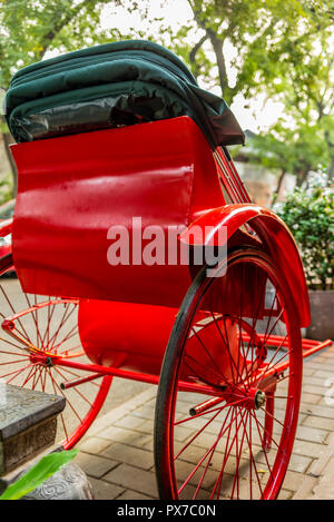 Eine helle rote Rikscha in einer Gasse in einem Pekinger Hutong - 3 Stockfoto