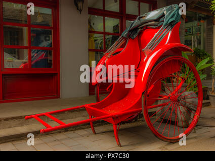 Eine helle rote Rikscha in einer Gasse in einem Pekinger Hutong - 1 Stockfoto