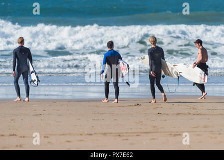 Surfen Cornwall - Surfer, die ihre Surfbretter und zu Fuß das Meer bei Fistral Beach in Newquay in Cornwall. Stockfoto