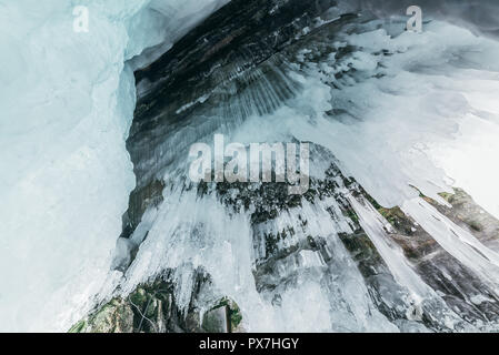 Winter Baikal. Insel Olchon. Eisgrotte. Dicke blaue Eis und Eiszapfen an der Küste Felsen der Insel Olchon im Winter. Natürliche Kälte Hintergrund. Der Gewinn Stockfoto