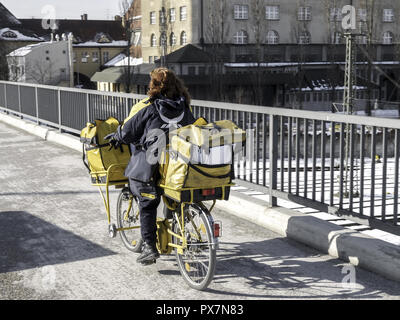 Weibliche Briefträger reiten auf einem Fahrrad, Deutschland, Bayern, München Stockfoto