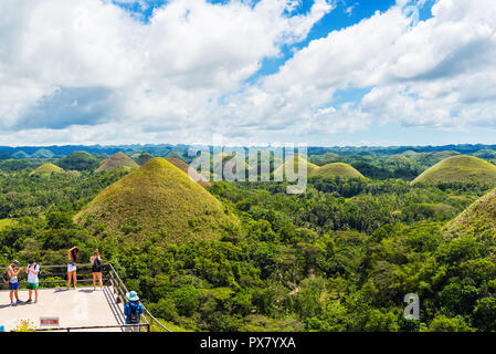 BOHOL, Philippinen - Februar 23, 2018: Menschen auf dem Hintergrund der Chocolate Hills an einem sonnigen Tag Stockfoto