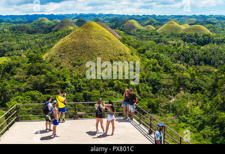 BOHOL, Philippinen - Februar 23, 2018: Menschen auf dem Hintergrund der Chocolate Hills an einem sonnigen Tag Stockfoto